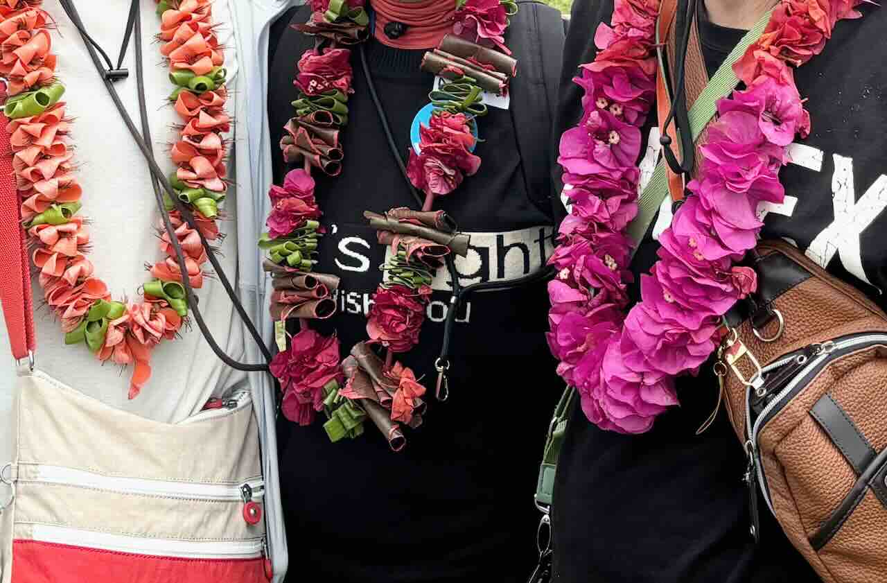 イースター島の学校訪問で、生徒たちがピースボート乗客の首に手作りの花のレイをかけて歓迎してくれた場面。鮮やかな花の色が、温かい笑顔と島の優しさを象徴している。