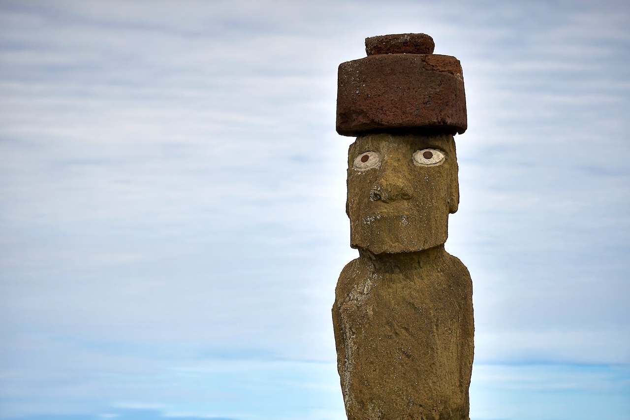 イースター島のタハイ遺跡に立つモアイ像。岸から最も近い場所にあり、白い目と赤い頭飾り（プカオ）が印象的。ピースボートからも遠目に見える象徴的な存在。