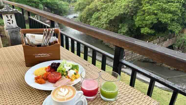 バリ島ウブドのスタラの朝食テーブル。コーヒーのラテアートとフレッシュジュースが印象的。