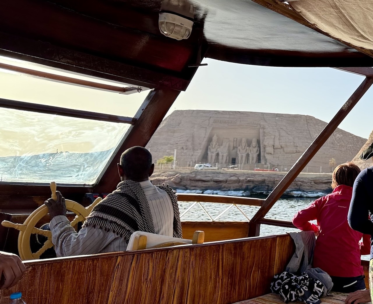 クルーズ船の操縦士と、遠くに見えるアブシンベル神殿