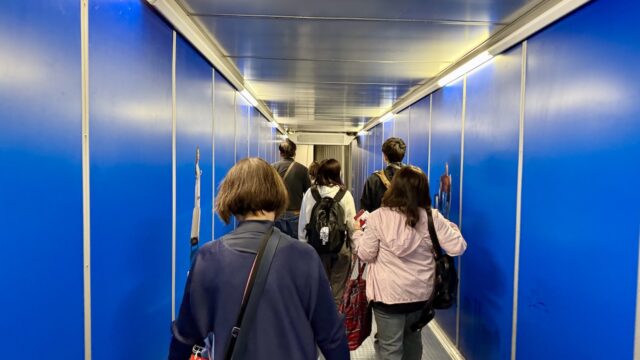 1. 搭乗ゲートの通路を歩く人々の後ろ姿