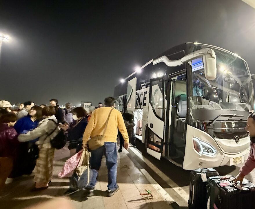 早朝に再びバスに乗る旅行者たち