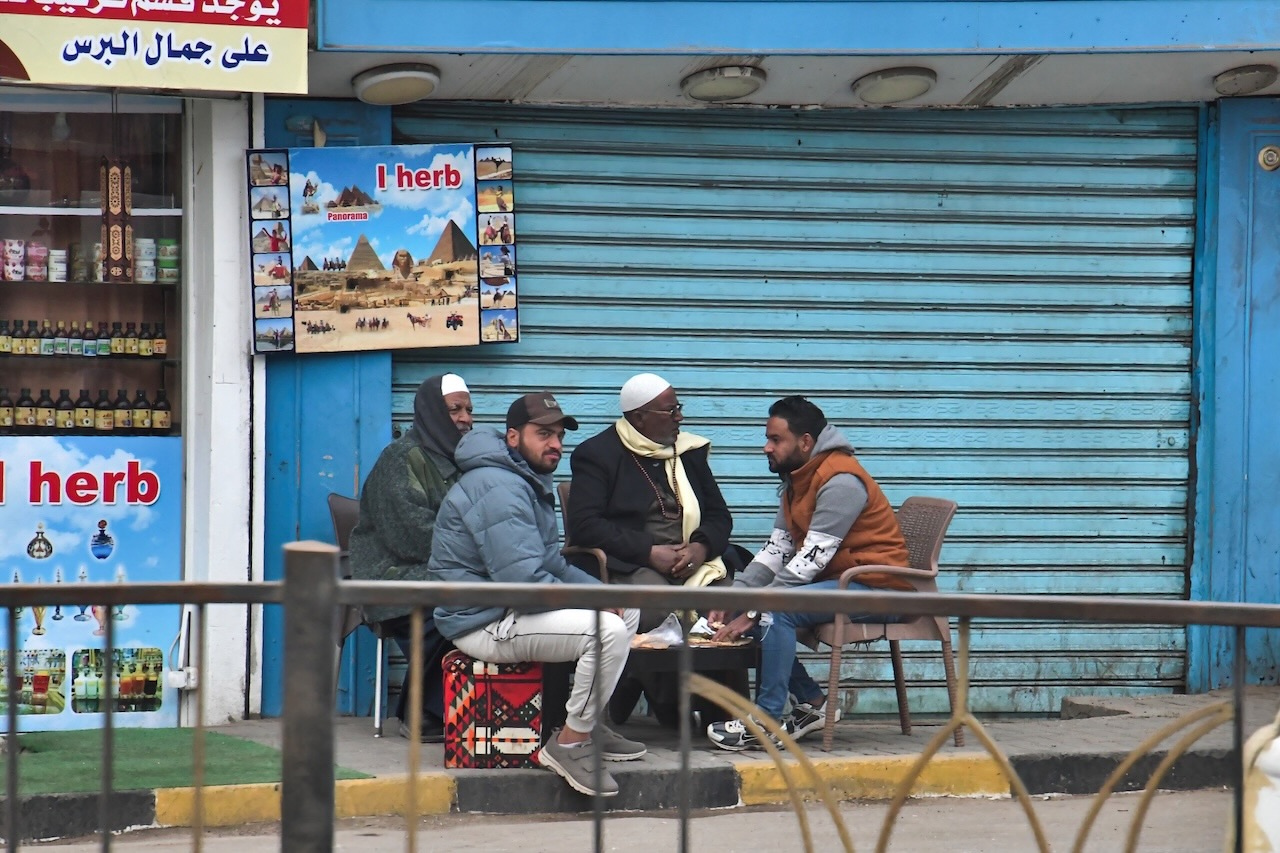 通りに面して椅子を囲む地元の男性たち