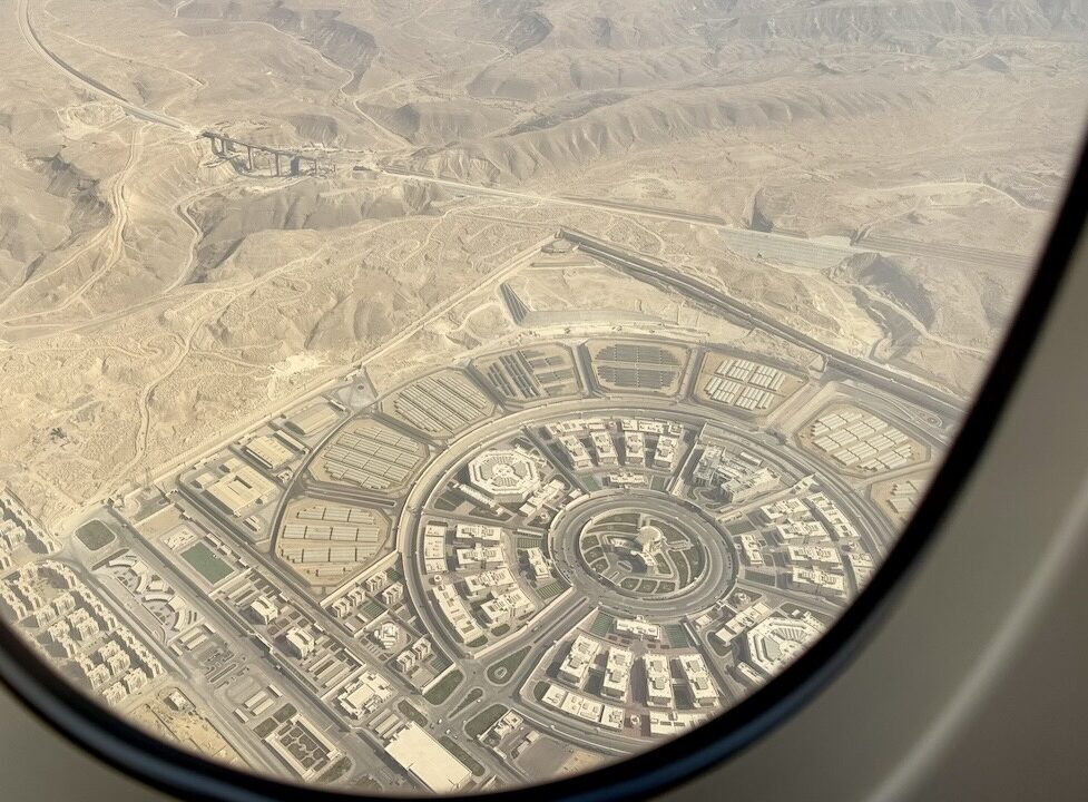 飛行機の窓から見た砂漠と円形の都市計画