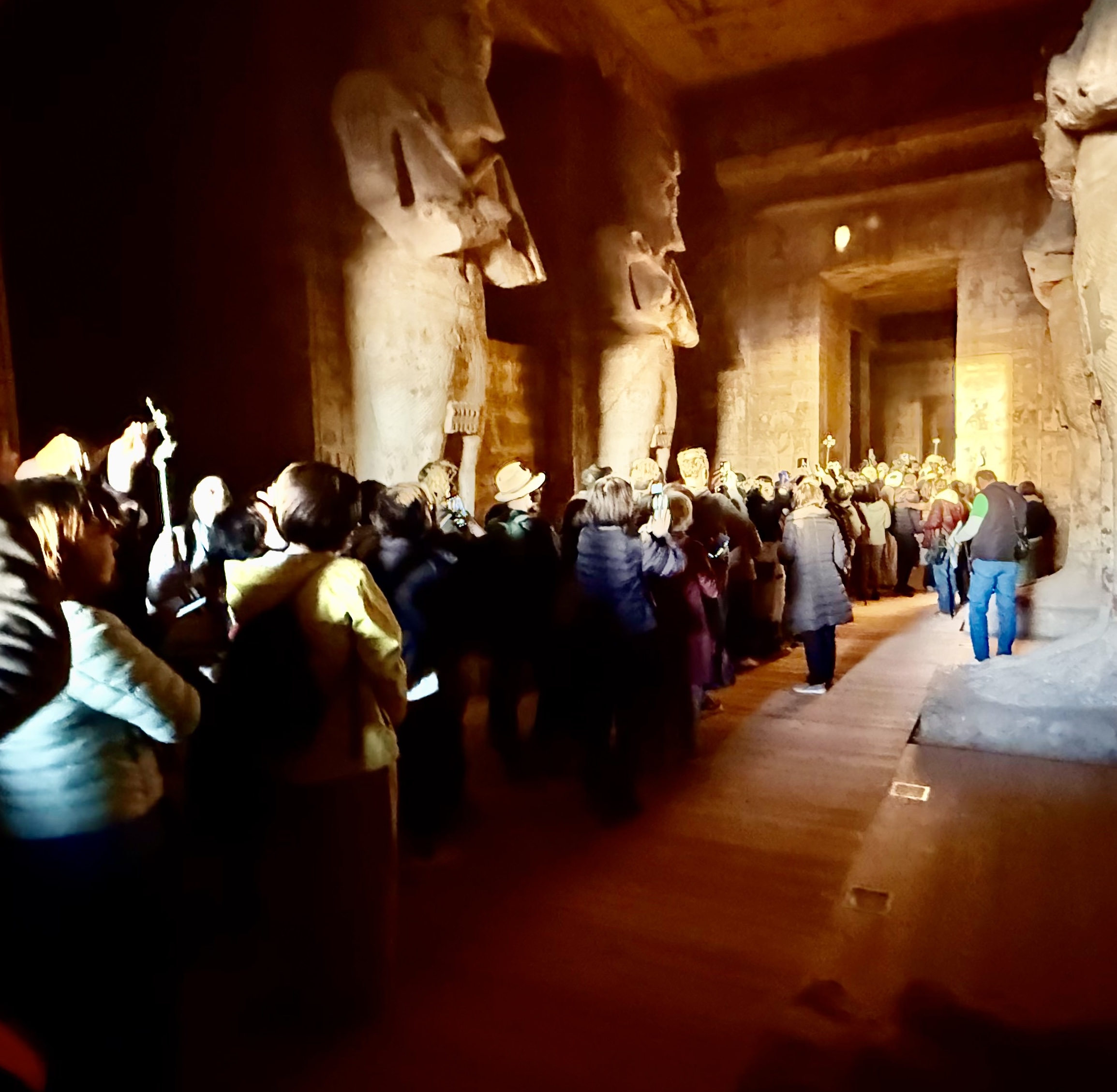 神殿内部で群衆が光の差し込みを撮影しようと集まる様子