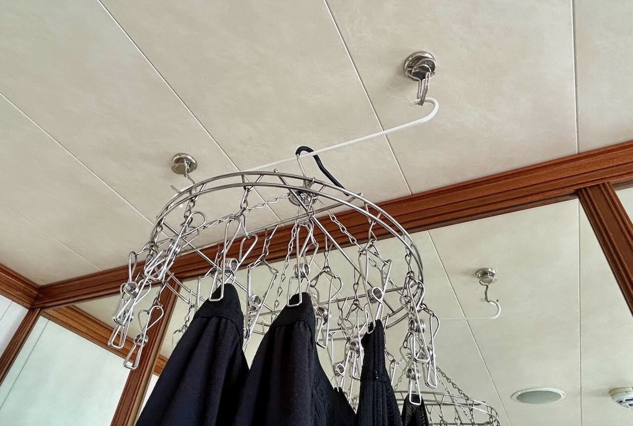 ピースボート船室で磁石フックと棒を使って洗濯物を干している様子