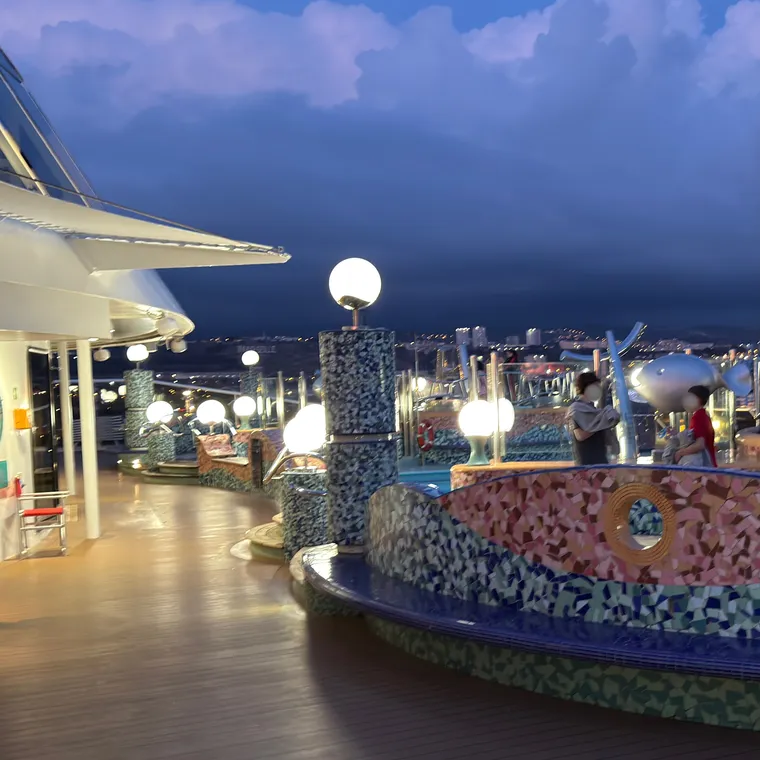 夕暮れの空の下で灯りがともるMSCスプレンディダのデッキ