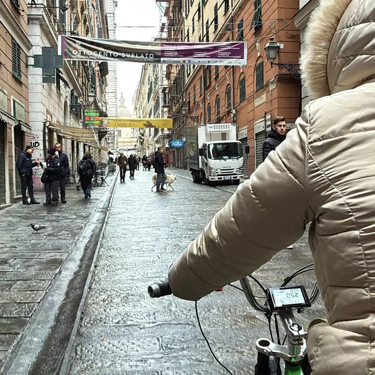 濡れた石畳の道を人力車で進むジェノバの旧市街