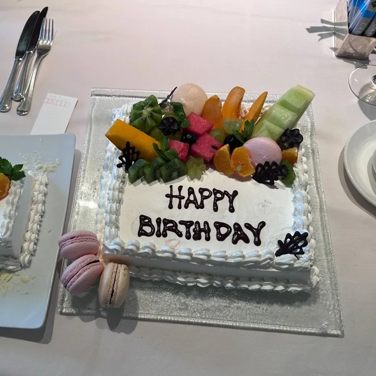 果物、マカロン、アイスクリームを飾った誕生日ケーキ