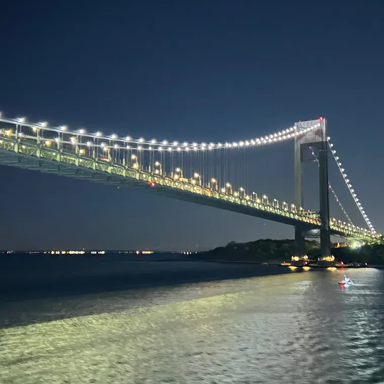 夜明け前の海上から見たライトアップされたヴェラザノ＝ナローズ・ブリッジ