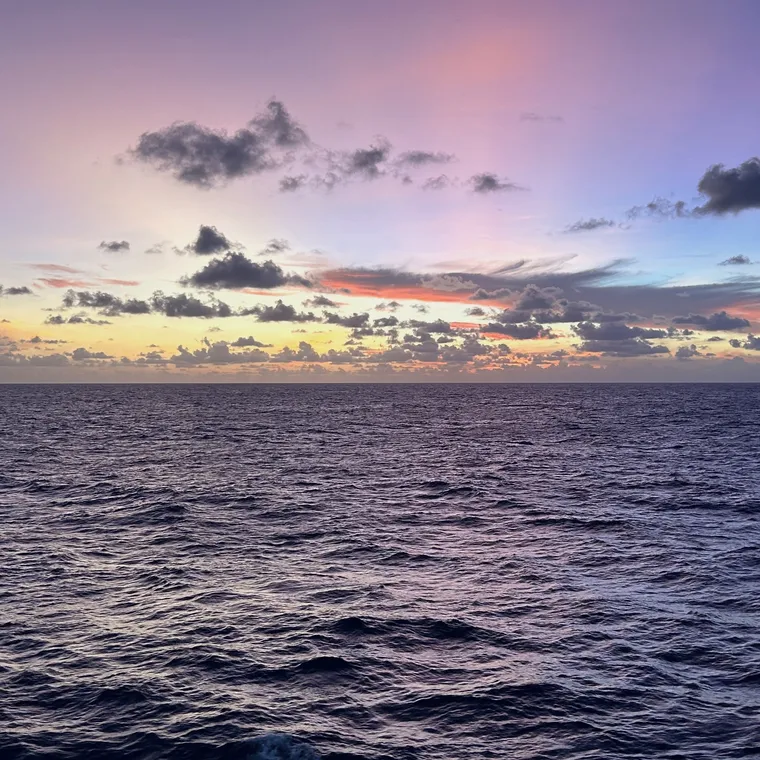 紫、ピンク、青が混ざり合う北太平洋の夕空と海