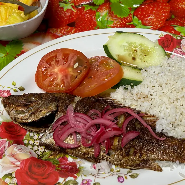 魚、ご飯、トマト、キュウリなどを盛り付けた夕食の皿