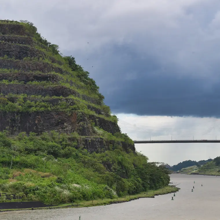 パナマ運河の緑の岸と、ゆるく曲がる水路を船上から見た景色