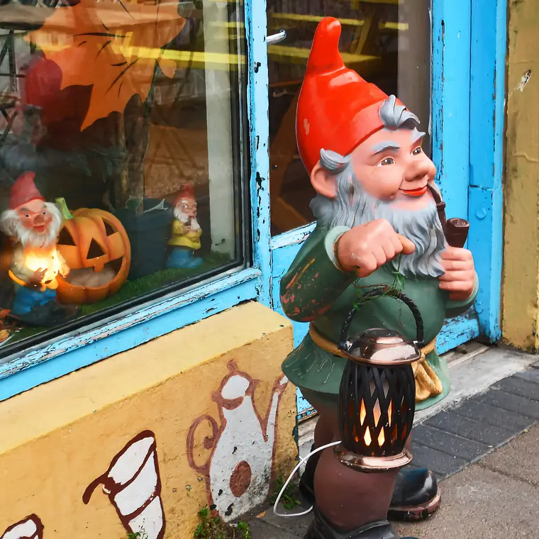 ハロウィン飾りの店先に置かれた赤い帽子の小人像