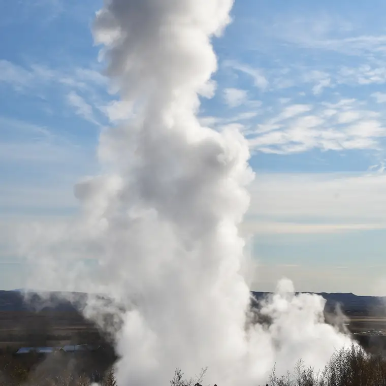 アイスランドのストロックル間欠泉から高く上がる白い噴気