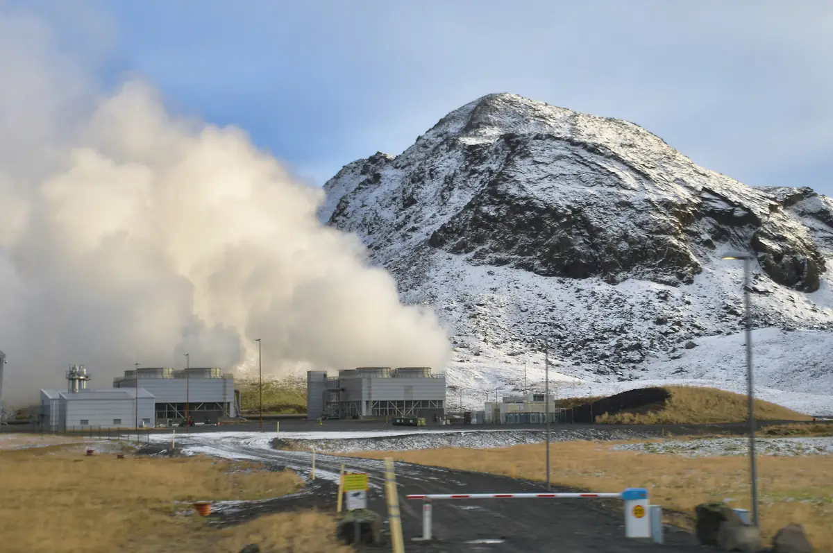 雪山のふもとで蒸気を上げるヘトリスヘイジ地熱発電所
