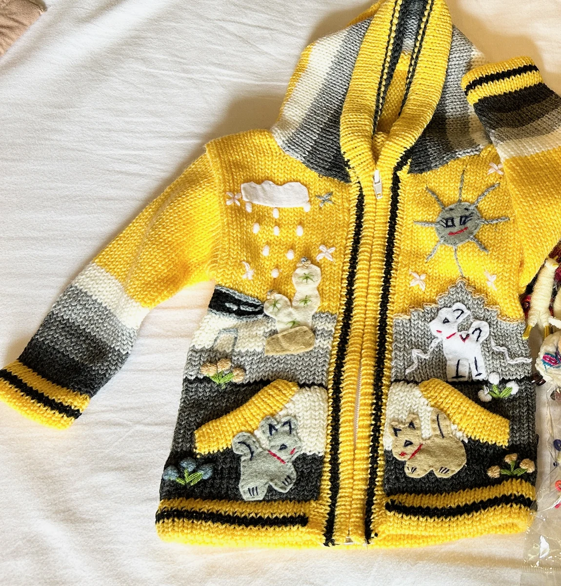 ペルーのカヤオ港で買った黄色い子ども用カーディガン。動物や花の飾り付き