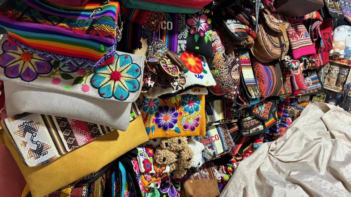 クスコのサンペドロ市場のお土産売り場に並ぶ色とりどりの刺繍入りポーチとバッグ