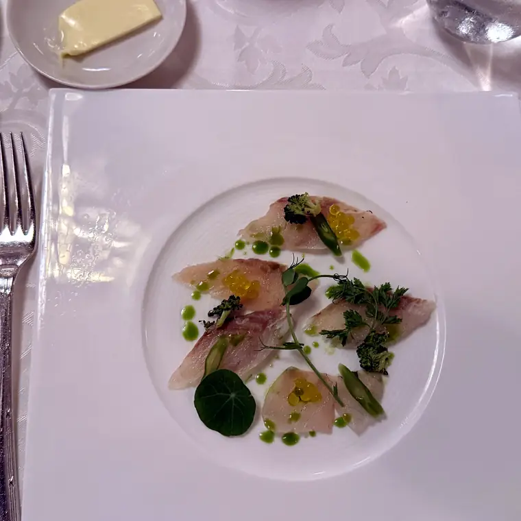 白い皿に盛られた、魚介を使った洋食の一皿