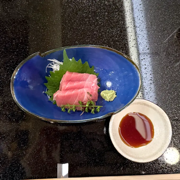 青い器に盛られた本鮪の刺身と薬味、醤油