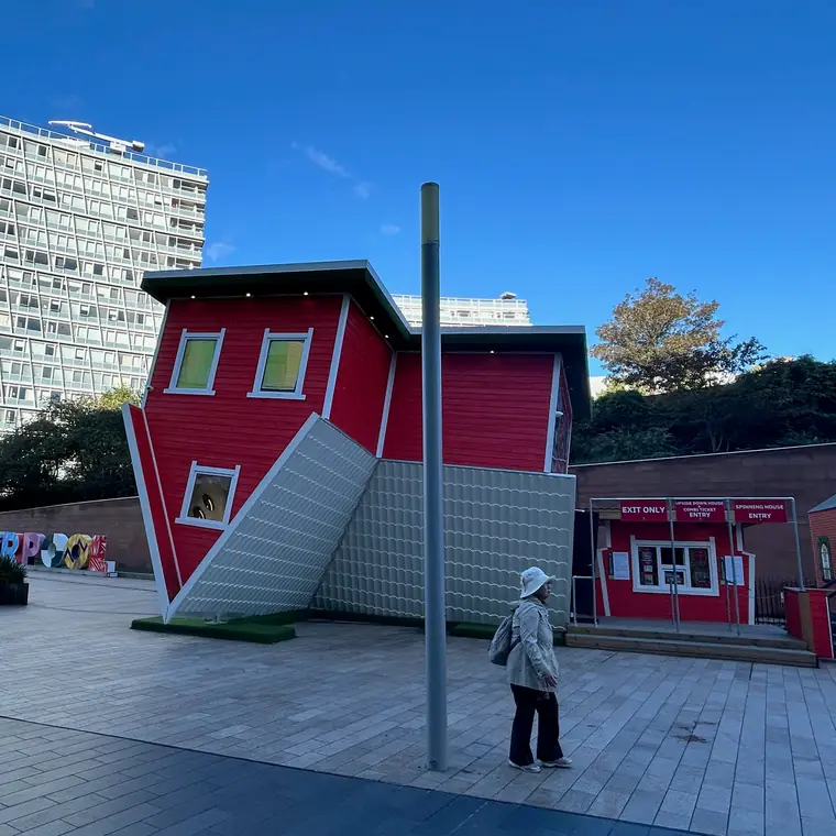 階段の付いた赤い家を傾けた形の建物