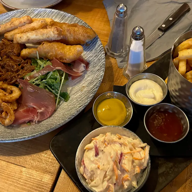 魚のフライなどを盛った大皿とポテトが並ぶ食卓