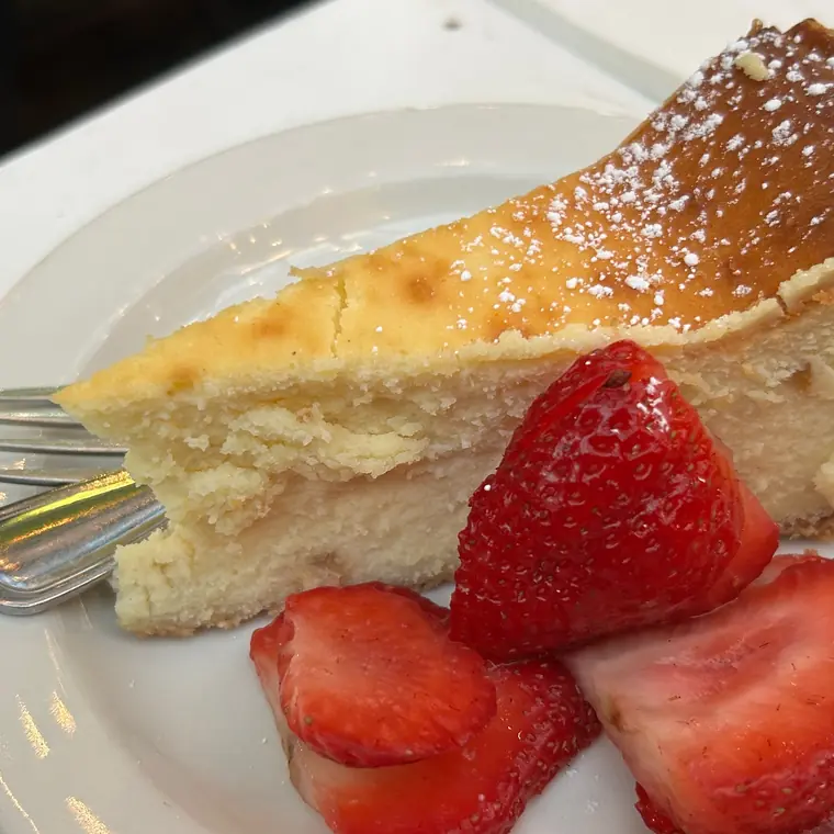 白い皿に盛られたいちご付きのチーズケーキ